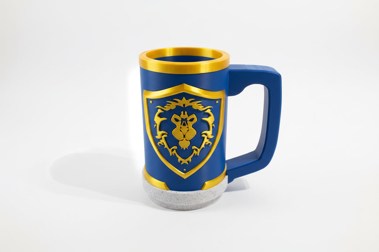 Blue alliance world of Warcraft mug with gold emblem on a gray surface