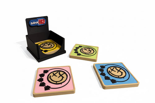 Set of coasters with a logo on a gray surface, featuring a black holder with 'blink 182' branding.